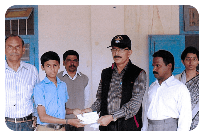 Presenting a cheque to Ammathi High School.