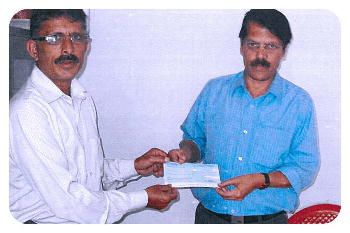 Marchanda Ganesh Ponnappa, Trustee, presenting a cheque to Rotary High School, Bittangala.
